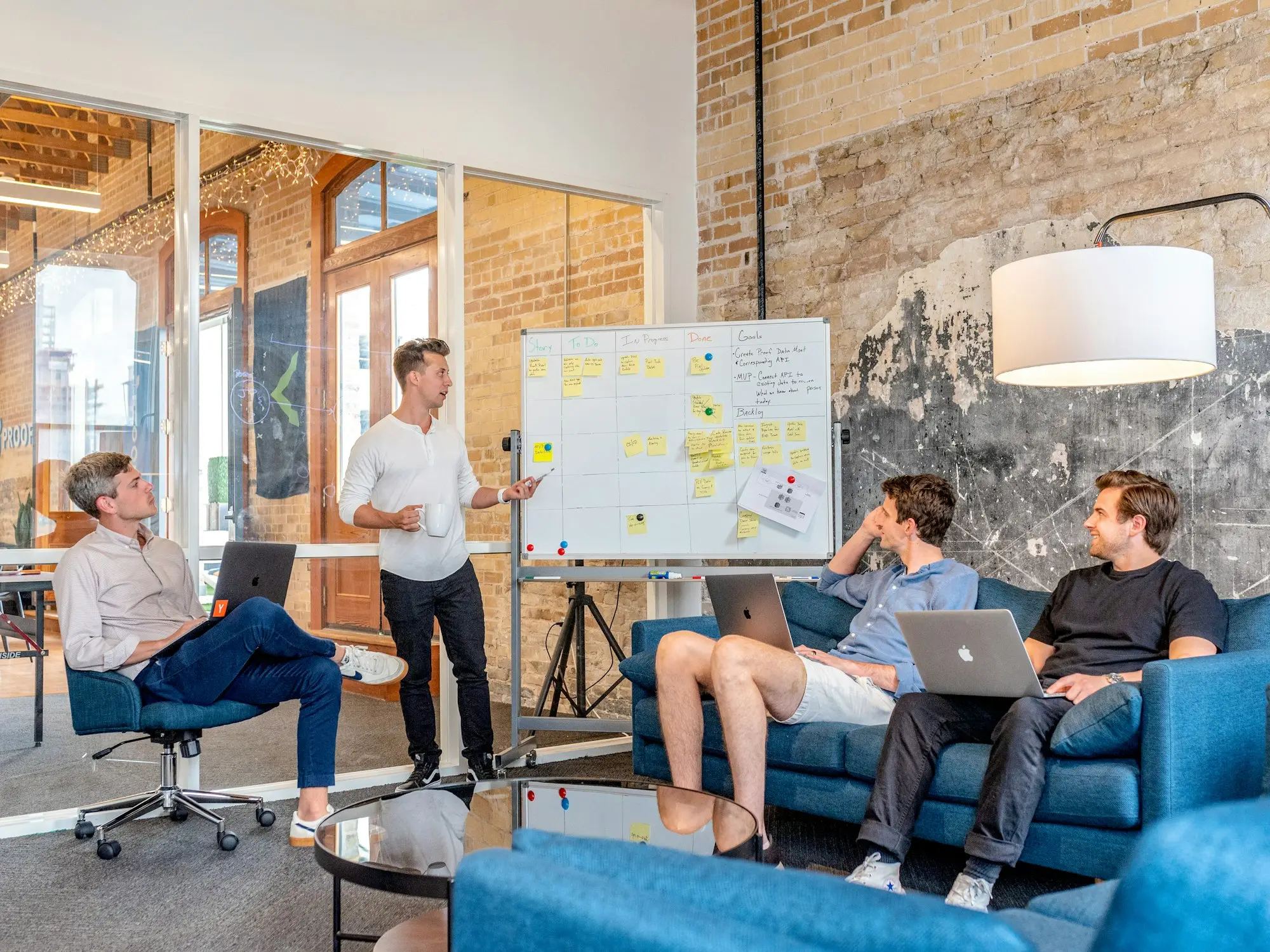 Small business team planning around a whiteboard in a warehouse office