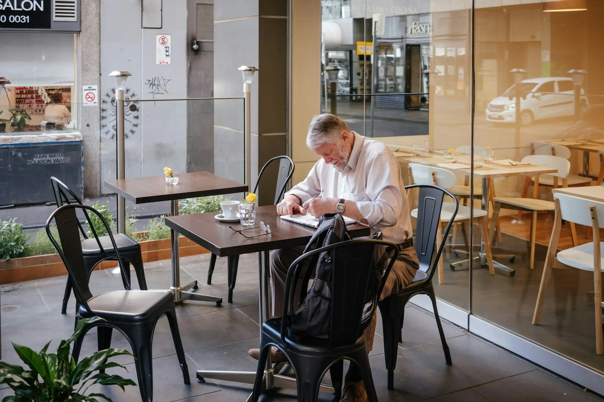 Business owner reading paperwork at a table in a glass-fronted Melbourne office