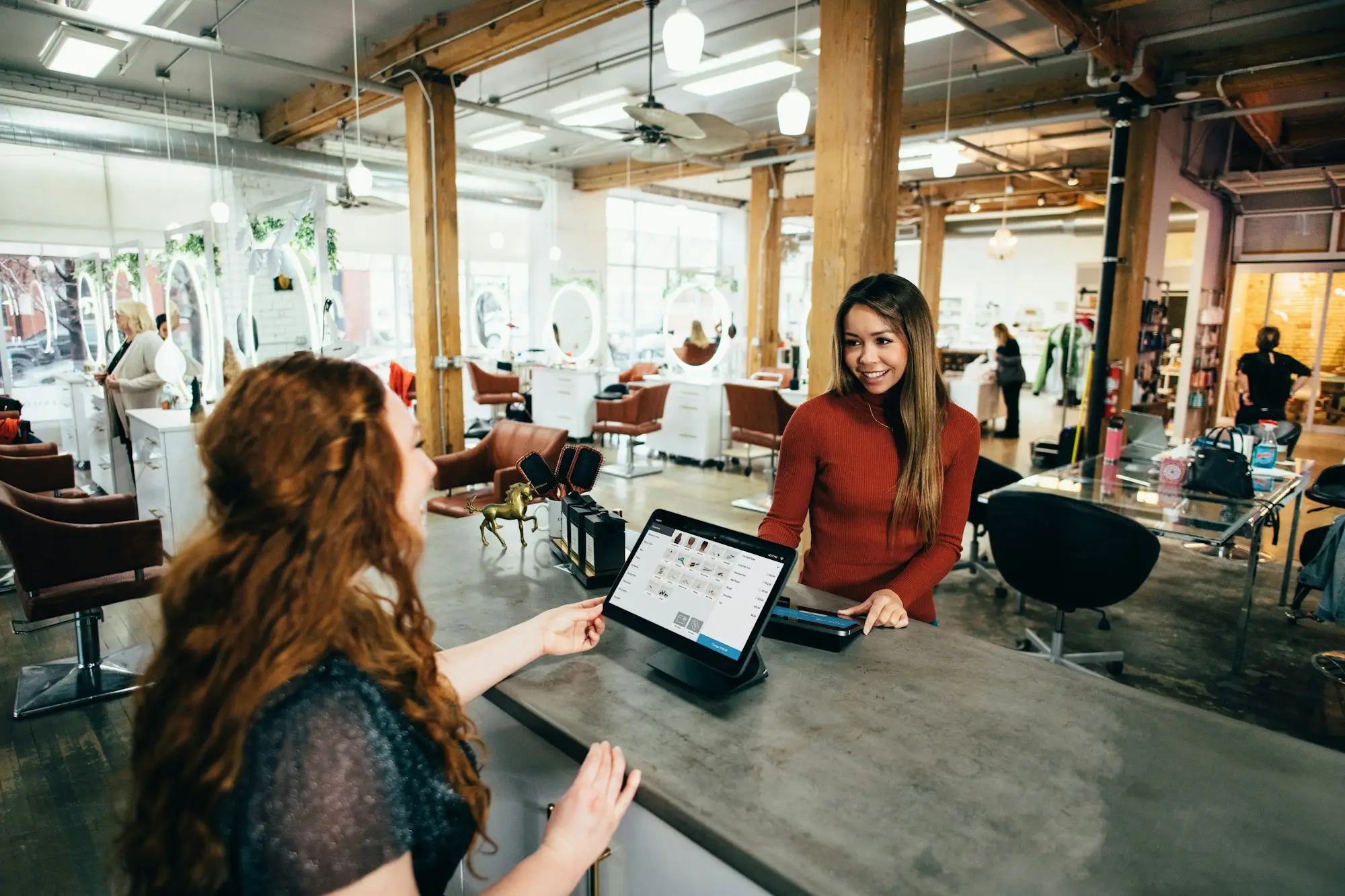 Retail business owners working on a tablet and laptop in a bright shop
