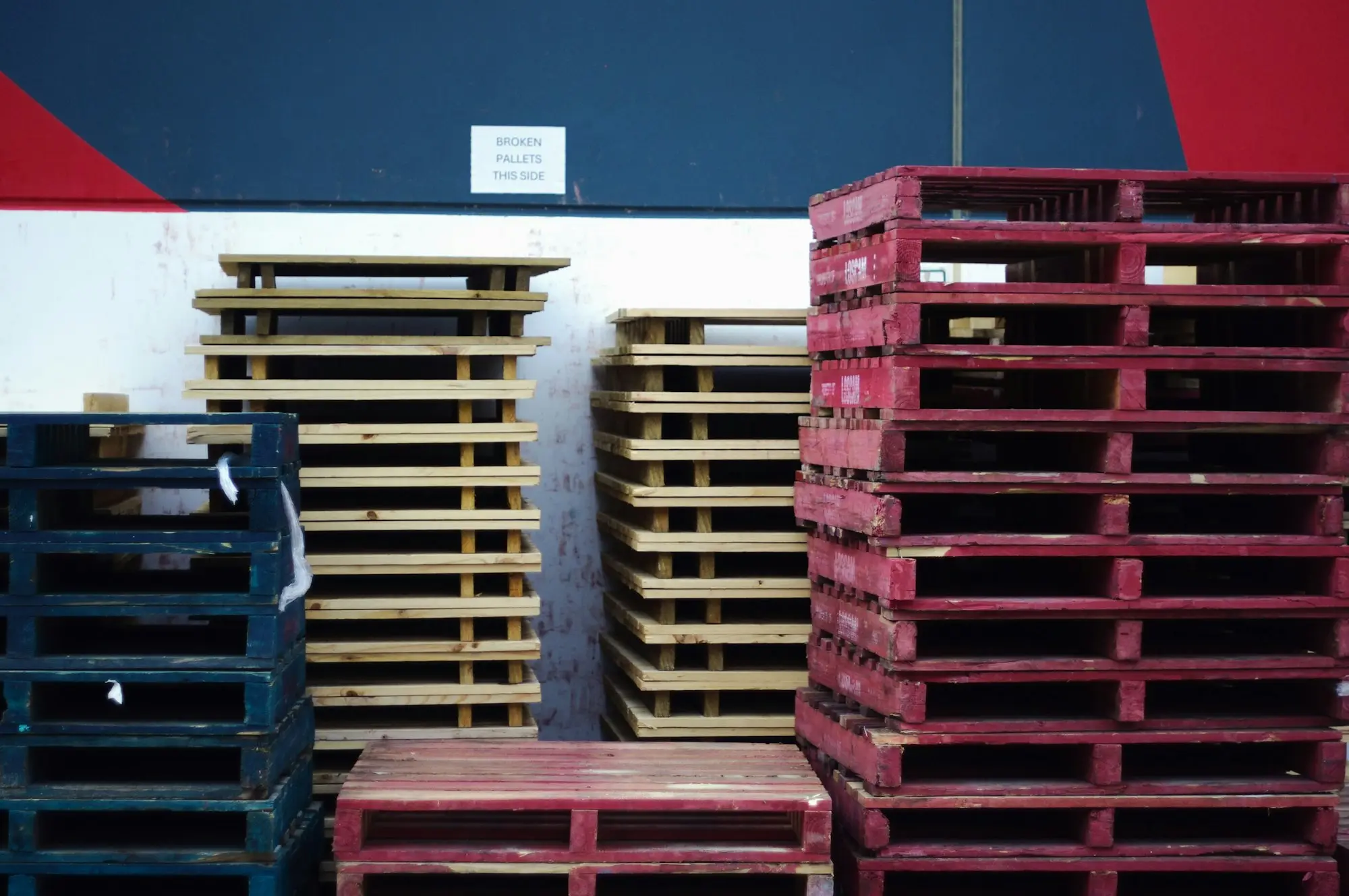 Stacks of blue and red pallets in a Perth warehouse